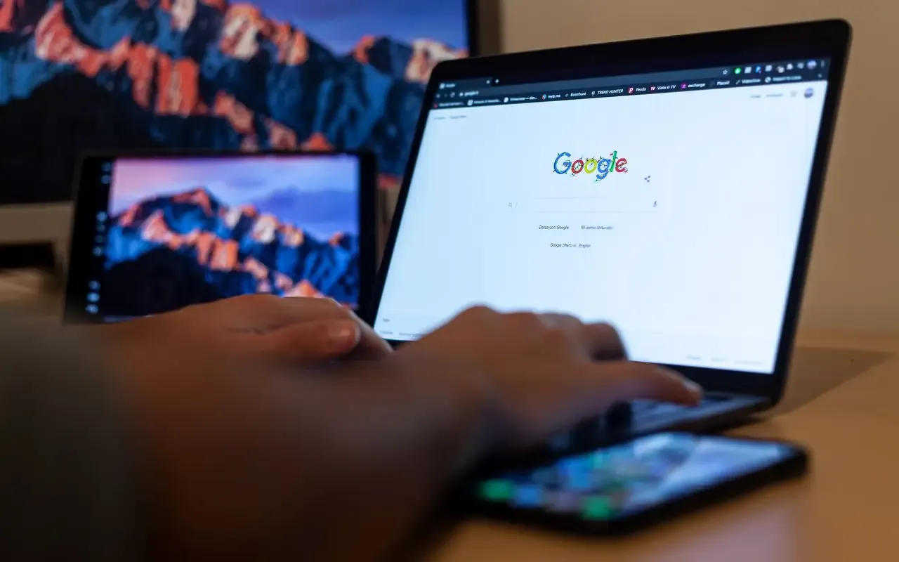 Mains sur un ordinateur portable ouvert sur un moteur de recherche